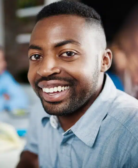 Smiling man in light blue shirt at professional orthodontics office setting