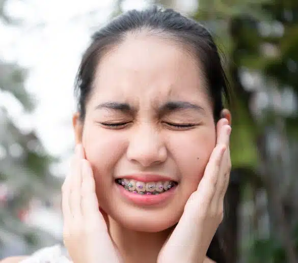 Teen patient holding Invisalign clear aligners at Elvebak Orthodontics in Plano, TX.
