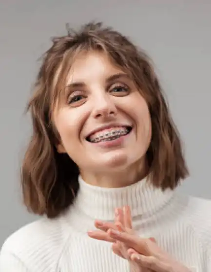 Young woman with ceramic braces smiling, orthodontist in Plano